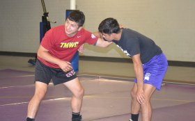Isaiah provides some pointers to a Lemoore High wrestler.